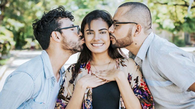 Woman being kissed by male lovers