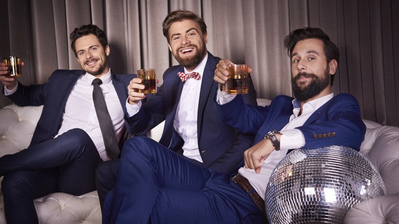Guys wearing suits toasting