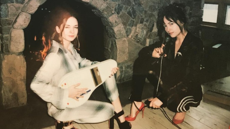 Dakota Johnson and Stella Banderas posing together by a fire