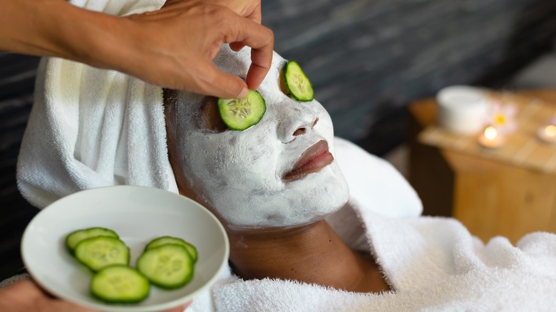 Woman using clay and dandelion facemask