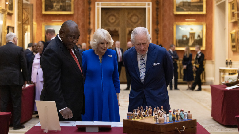 Charles and Camilla at Royal Collection event, looking at chess set