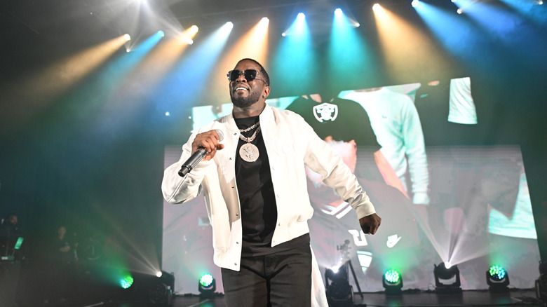 Sean "Diddy" Combs stands on a stage with a microphone in his hand