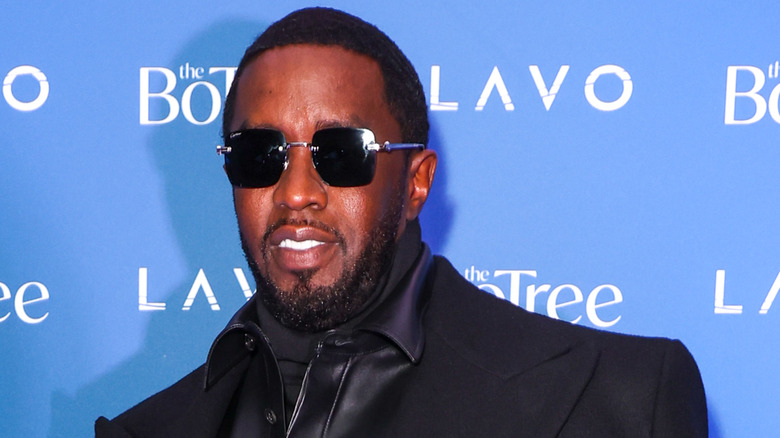 Sean Diddy Combs posing in sunglasses and a black coat