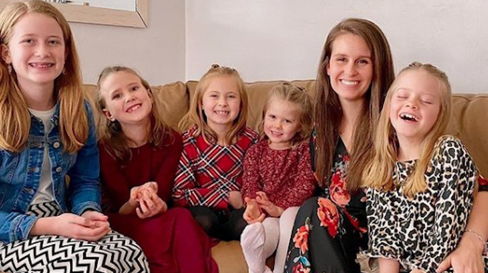 Erica Shemwell and her daughters smile on a couch