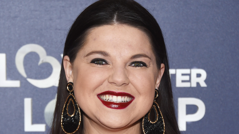 Amy Duggar smiling on the red carpet