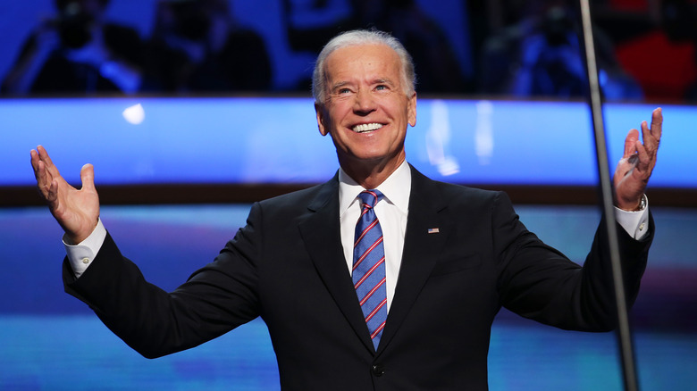 President Joe Biden holds up his hands onstage