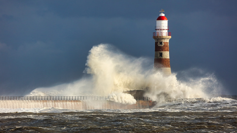 waves crashing on a lighthouse