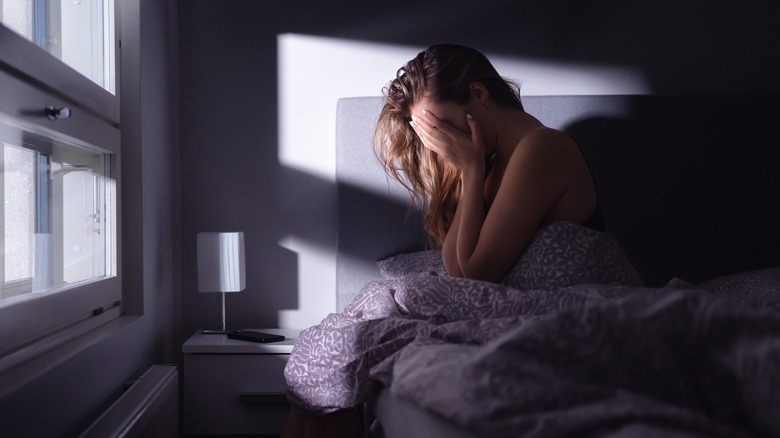 A woman sitting in bed at night