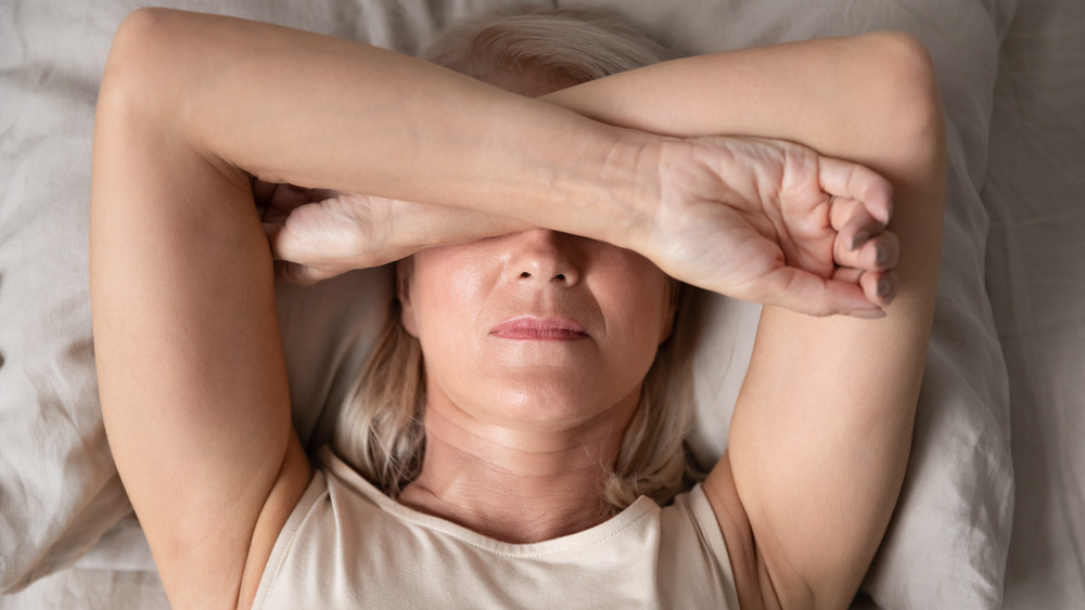 A woman covering her eyes with her arms 