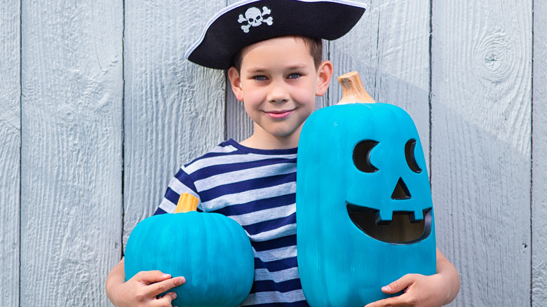 Boy dressed as pirate with teal pumpkins