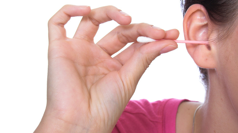 Pink cotton swab in ear