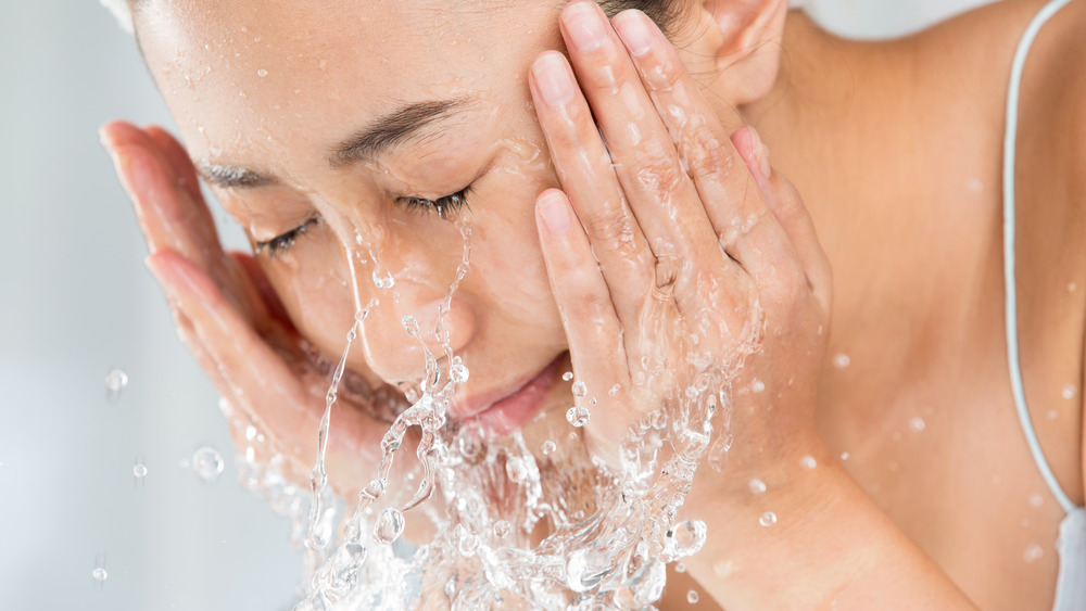 Woman washing her face.