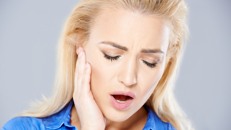 woman holding her jaw