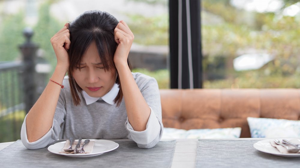 Woman stressed and eating alone