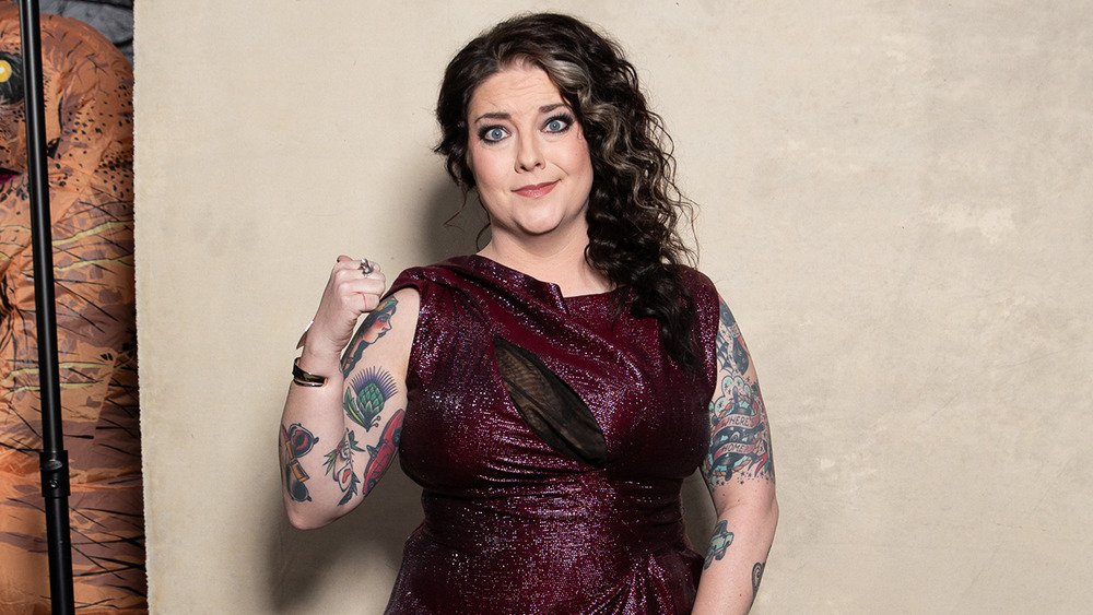 Ashley McBryde shows her fist in a maroon gown