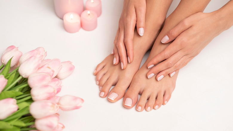 Feet with a pedicure with manicured hands also