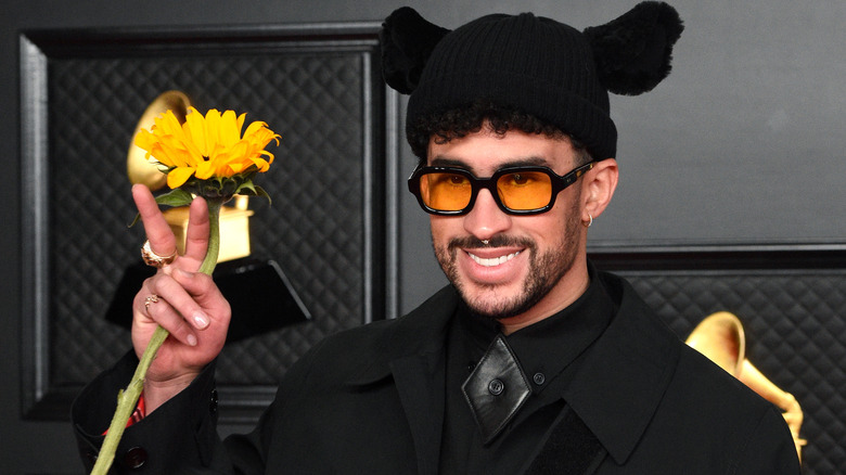 Bad Bunny smiling, holding a sunflower