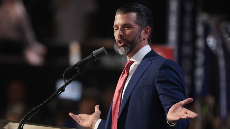 Donald Trump Jr. speaking at microphone