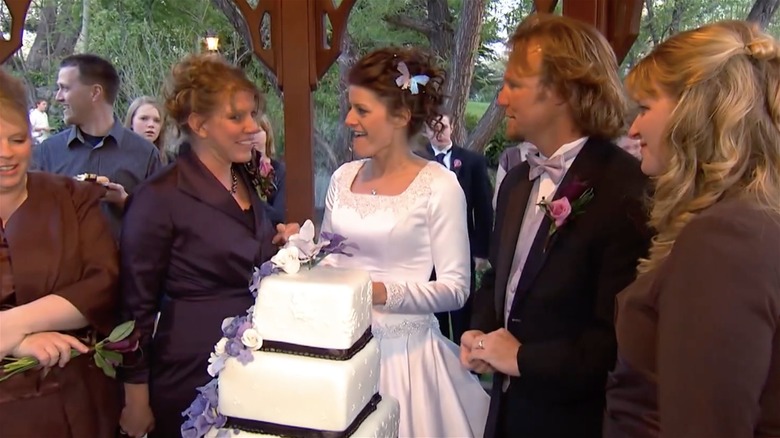 Kody and Robyn Brown speaking to wives in front of wedding cake