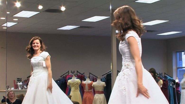 Robyn Brown in wedding dress looking at herself in mirror