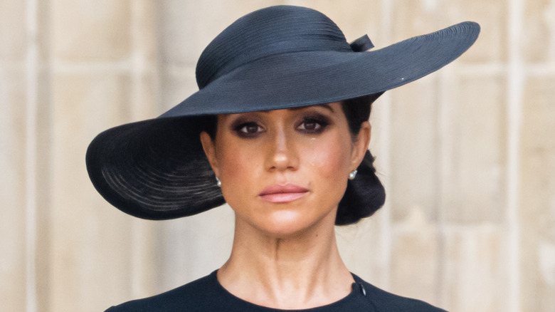 Meghan Markle crying in black hat