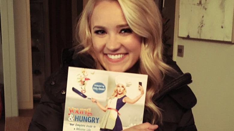 Emily Osment holding a cookbook