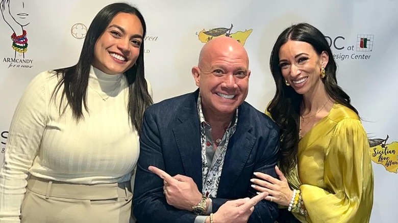 Eric Eremita posing with two women