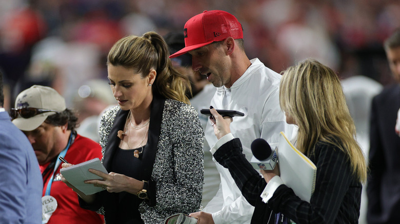 Erin Andrews reporting on the sidelines of a football game 