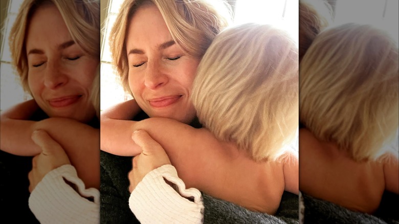 Close-up photo of Erin Napier embracing her young daughter