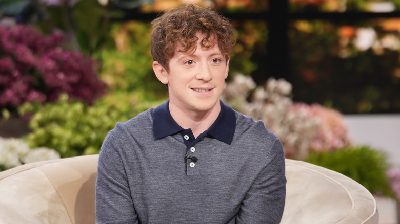 Actor Ethan Slater sitting on a sofa being interviewed