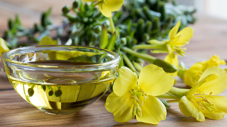 Fresh evening primrose flowers and oil in a bowl