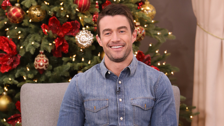 Robert Buckley in front of a Christmas tree