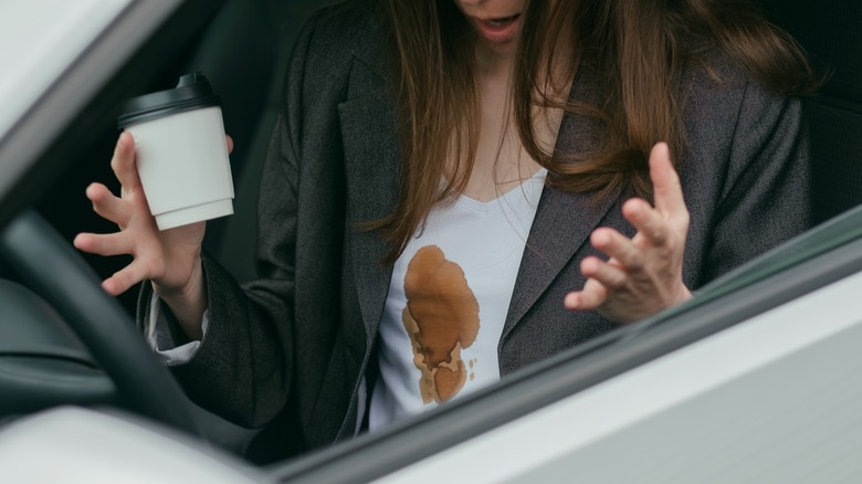 Woman in car with coffee-stained top