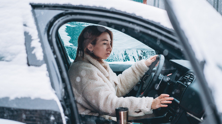 Woman sitting in car in snow