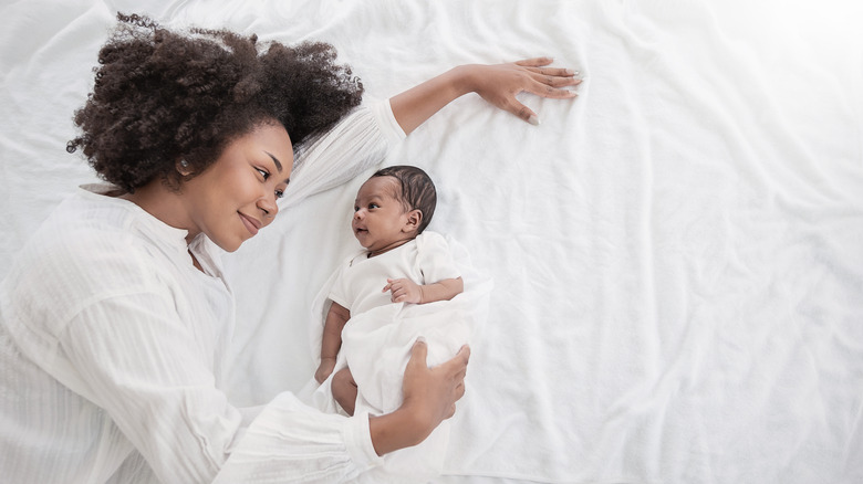 Woman looking lovingly at newborn baby