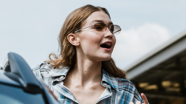 Gigi Hadid open-mouthed with sunglasses and a check shirt