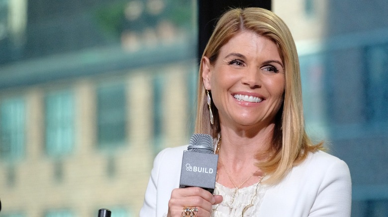 Actor Lori Loughlin laughing with a mic