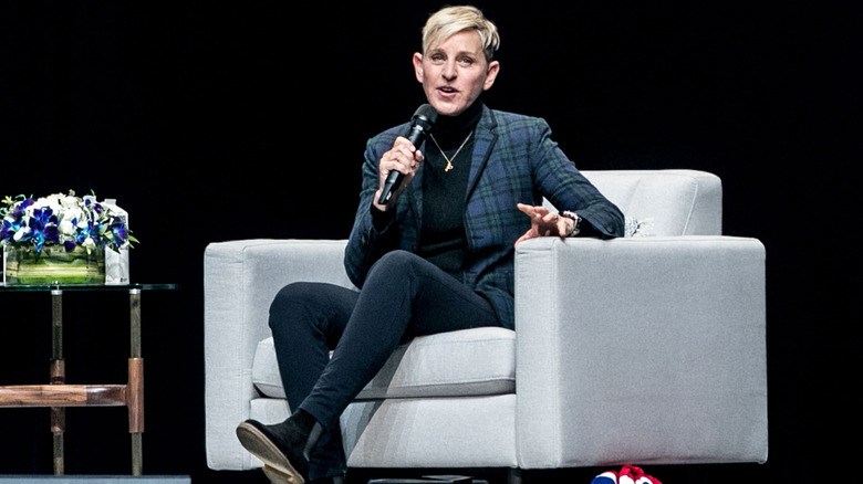 Ellen DeGeneres sitting on sofa with microphone