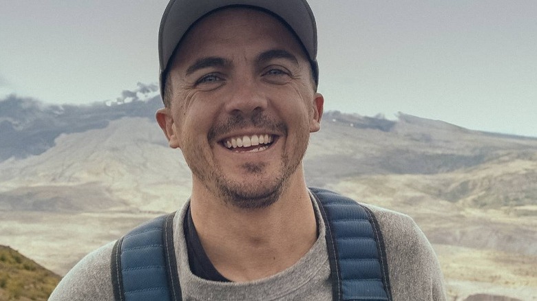 Frankie Muniz smiling while hiking