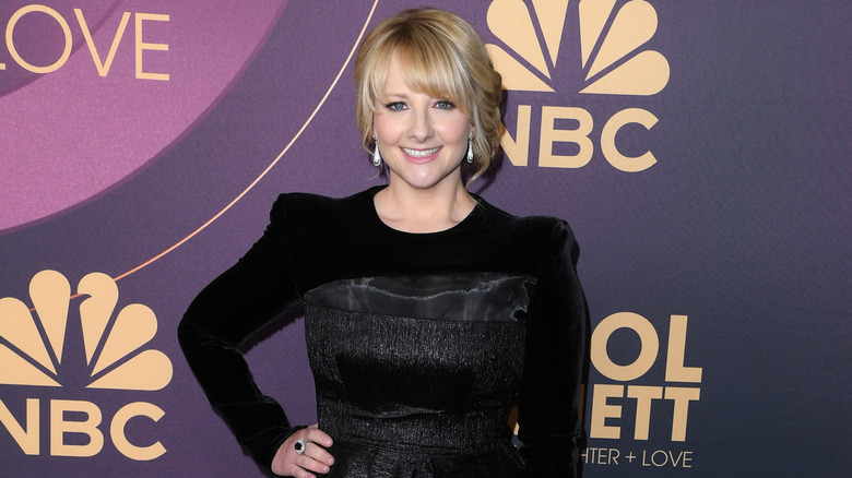 Melissa Rauch smiling on step-and-repeat