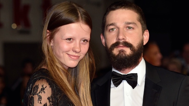 Mia Goth smiling, Shia LaBeouf frowning