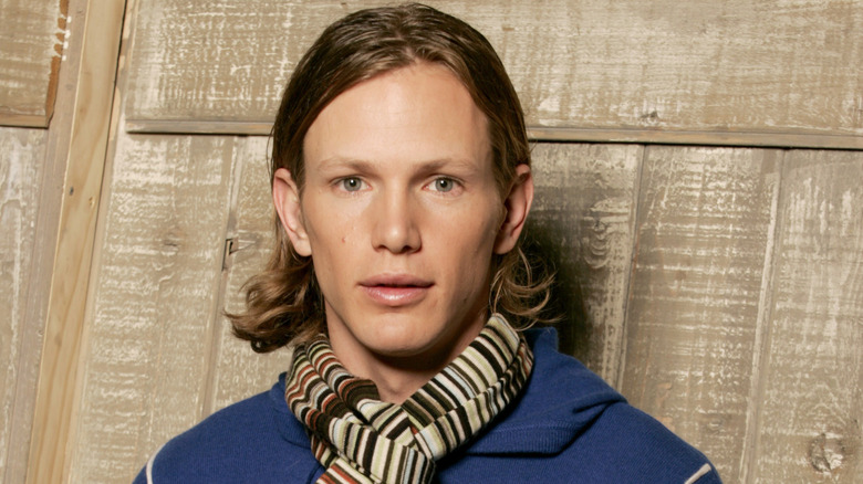 Kip Pardue posing in front of a wood wall