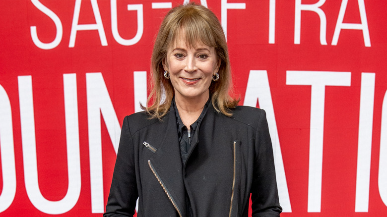 Smiling Patricia Richardson with a red background 