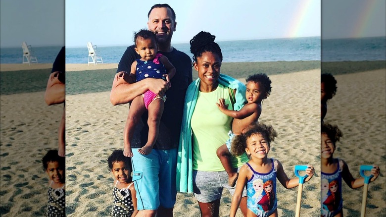 Dominique Dawes posing with her husband and kids