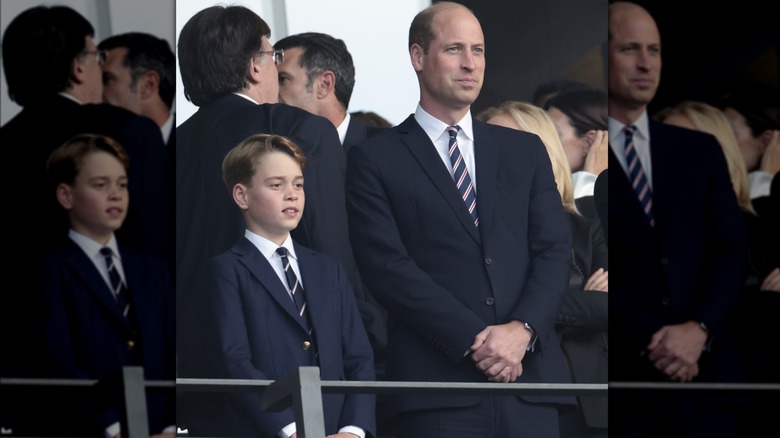 Prince William and Prince George standing in soccer stands