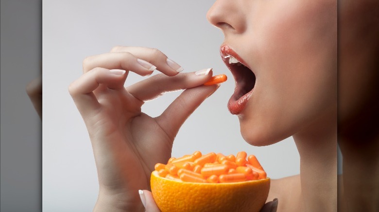 Woman taking a vitamin C tablet 