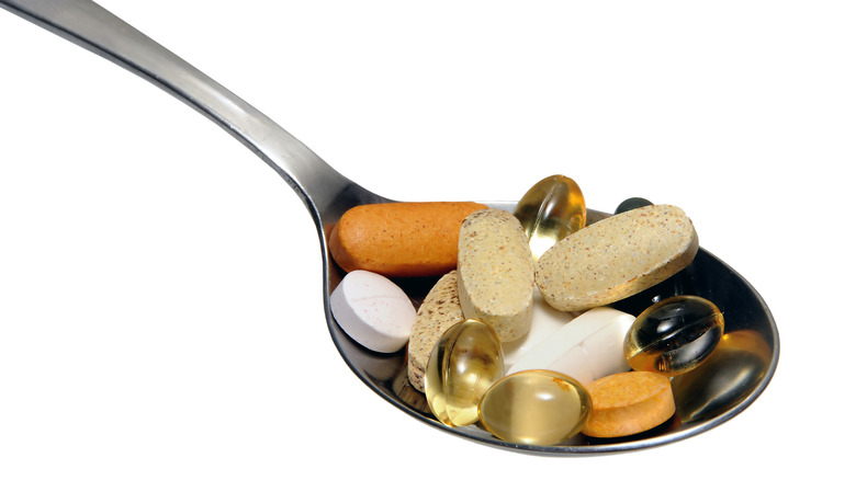 Vitamins and minerals on a silver spoon