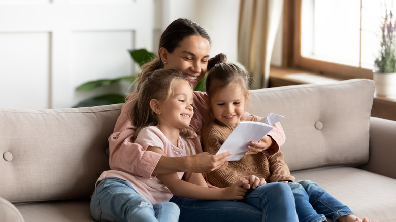 Mother reading with daughters