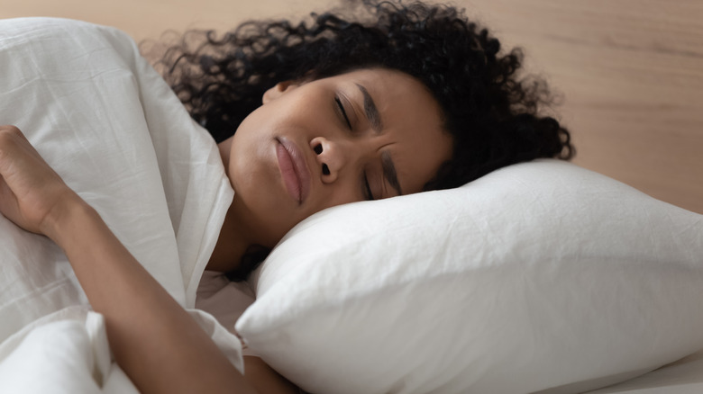 A woman sleeping in bed because of daylight savings time