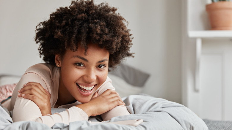 A happy, awake woman in bed